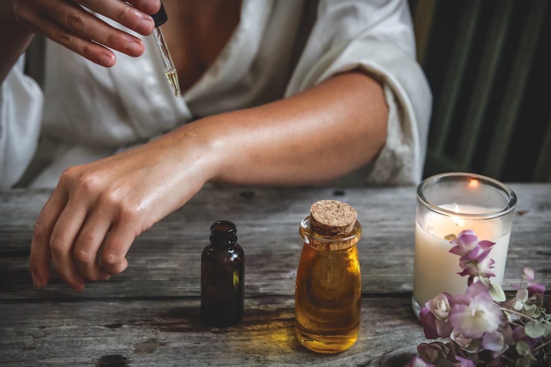 CBG (cannabigerol) oil is amazing for the skin. Photo is of a woman adding droplets of hemp oil to her arm from a glass pipette.