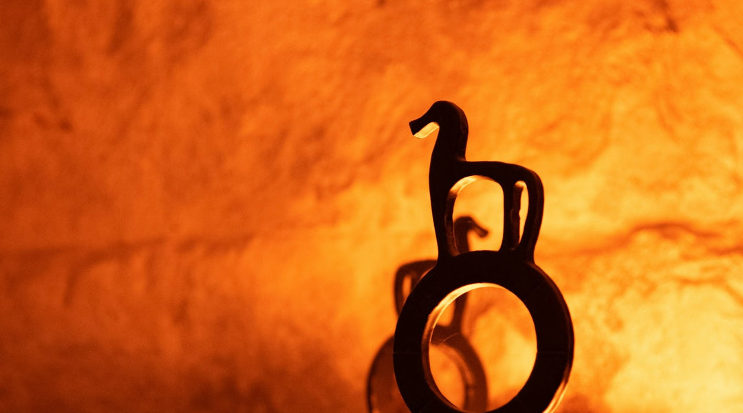 Photo of a silhouette of a metal horse statue against a fiery wall to represent Chinese New Year Fire Horse energy. Photo by Bozhin Karaivanov.